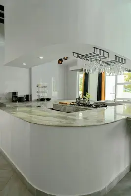 a large white room with a large counter with glasses at The Garden Escape Villa, Private Tropical Hideaway in Rawai Beach
