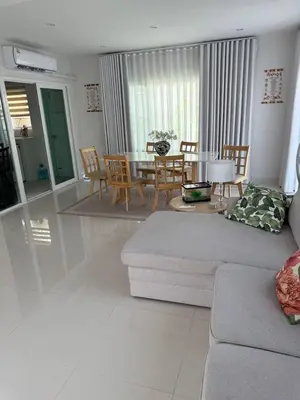 a living room with a couch and a table and chairs at La Perla Residence in Ban Phak Chit