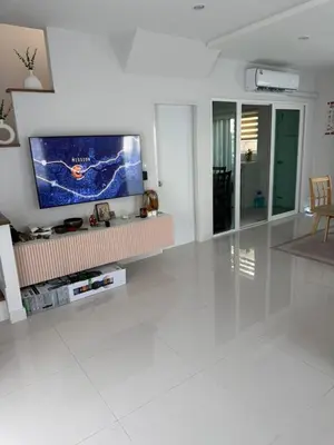 a living room with a flat screen tv on the wall at La Perla Residence in Ban Phak Chit