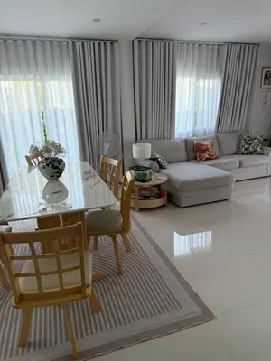 a living room with a table and a couch at La Perla Residence in Ban Phak Chit