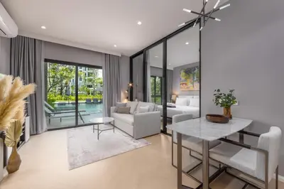 a living room with a couch and a table at Porto 1BR Pool Access Suite at Title Legendary in Bang Tao Beach