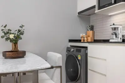 a kitchen with a washing machine and a table at Porto 1BR Pool Access Suite at Title Legendary in Bang Tao Beach