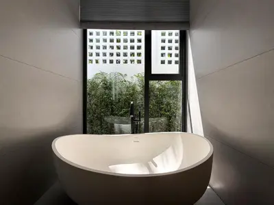 a large white bath tub in front of a window at Clover Residence Villa Phuket in Koh Lone