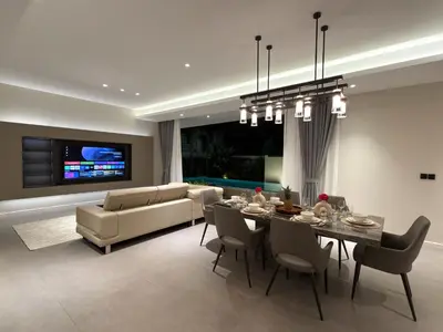 a living room with a dining table and a couch at Clover Residence Villa Phuket in Koh Lone