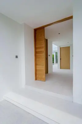 a room with white walls and a wooden door at Brand New Asherah Pool Villa next to Bangtao Beach VVPHU52 in Ban Riang