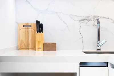 a kitchen counter with a knife block and a sink at KORA 2BR LUXURY POOL VIEW Apartment in Layan Beach