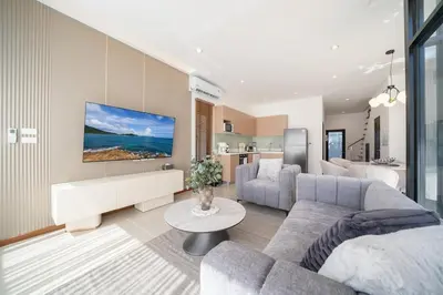 a living room with a couch and a tv at Lelux Villa Kamala - Goldena Twin in Kamala Beach