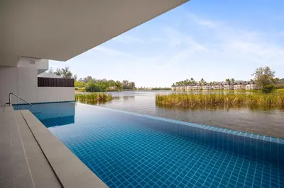 a swimming pool with a view of a river at Angsana Oceanview Residences Building 3 in Laguna by Banyan Living in Laguna Phuket