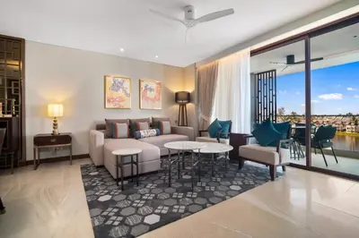 a living room with a couch and a table and chairs at Angsana Oceanview Residences Building 3 in Laguna by Banyan Living in Laguna Phuket