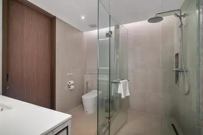 a bathroom with a glass shower and a toilet at Angsana Oceanview Residences Building 3 in Laguna by Banyan Living in Laguna Phuket