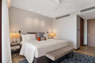 a bedroom with a large white bed with two lamps at Angsana Oceanview Residences Building 3 in Laguna by Banyan Living in Laguna Phuket