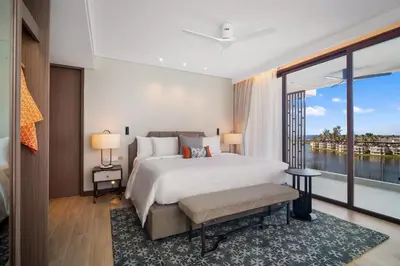 a bedroom with a large bed and a large window at Angsana Oceanview Residences Building 3 in Laguna by Banyan Living in Laguna Phuket