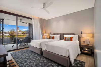 two beds in a hotel room with a balcony at Angsana Oceanview Residences Building 2 in Laguna by Banyan Living in Thalang