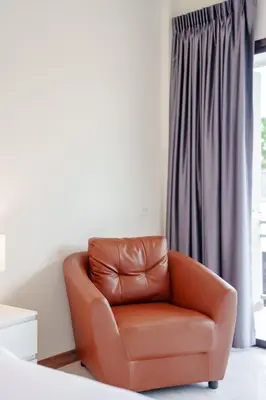 a brown leather chair sitting in front of a window at B201 Banjong Studio 3 Minutes To Nai Harn Beach in Rawai Beach