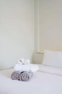 a pile of towels sitting on top of a bed at B203 Banjong Studio 3 Minutes To Nai Harn Beach in Rawai Beach