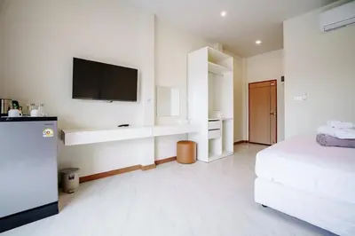 a white room with a bed and a flat screen tv at B203 Banjong Studio 3 Minutes To Nai Harn Beach in Rawai Beach