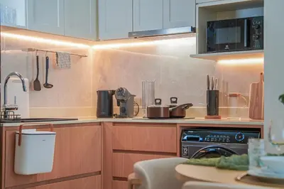 a kitchen with wooden cabinets and a stove top oven at Brand New Premium beachfront apartments! in Bang Tao Beach