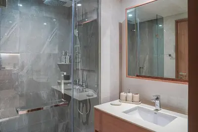 a bathroom with a sink and a glass shower at Brand New Premium beachfront apartments! in Bang Tao Beach