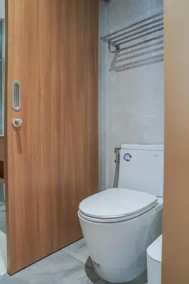 a bathroom with a white toilet and a wooden door at Brand New Premium beachfront apartments! in Bang Tao Beach