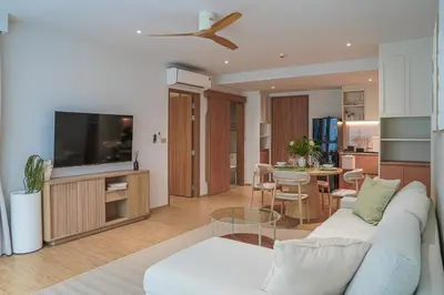 a living room with a couch and a tv at Brand New Premium beachfront apartments! in Bang Tao Beach