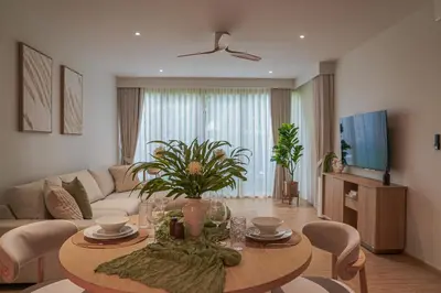 a living room with a table and a couch at Brand New Premium beachfront apartments! in Bang Tao Beach