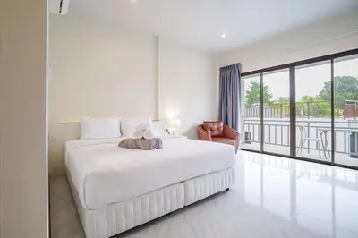 a white bedroom with a large bed and a balcony at B204 Banjong Studio 3 Minutes To Nai Harn Beach in Rawai Beach