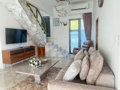 a living room with a couch and a tv at Santong Villa Rawai in Rawai Beach