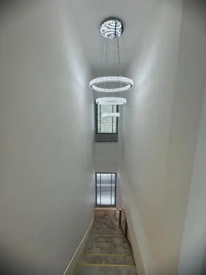 a staircase with a window and a chandelier at Santong Villa Rawai in Rawai Beach