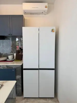 a white refrigerator in a kitchen with blue cabinets at Santong Villa Rawai in Rawai Beach