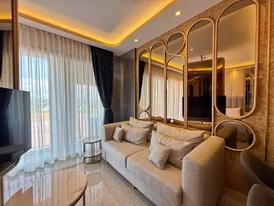 a living room with a couch and a television at Bellevue Lagoon Phuket in Laguna Phuket