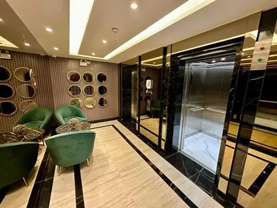 a dressing room with green chairs and a glass door at Bellevue Lagoon Phuket in Laguna Phuket