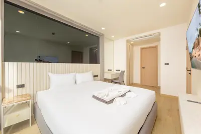 a bedroom with a white bed and a large mirror at Ozone Сondo Apart Hotel by TropicLook in Laguna Phuket
