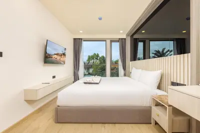 a bedroom with a white bed and a large window at Ozone Сondo Apart Hotel by TropicLook in Laguna Phuket