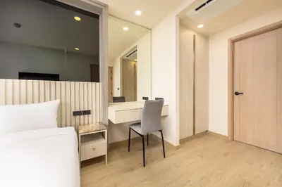 a bedroom with a bed and a desk and a chair at Ozone Сondo Apart Hotel by TropicLook in Laguna Phuket