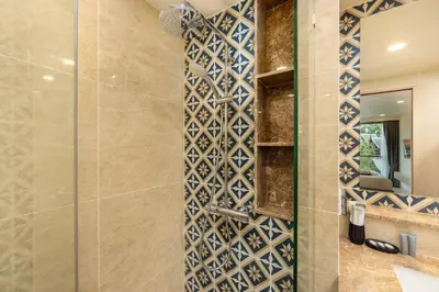 a bathroom with a shower with a tile wall at Ozone Сondo Apart Hotel by TropicLook in Laguna Phuket