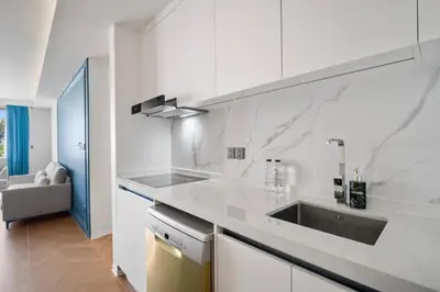 a white kitchen with a sink and a counter at Premier Kora 3-Bedroom Apartment E333 Beachfront in Phuket Town
