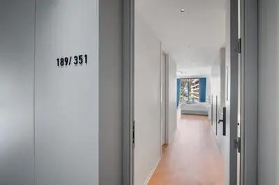 a hallway with white walls and a door with a sign on it at Premier Kora 3-Bedroom Apartment E333 Beachfront in Phuket Town