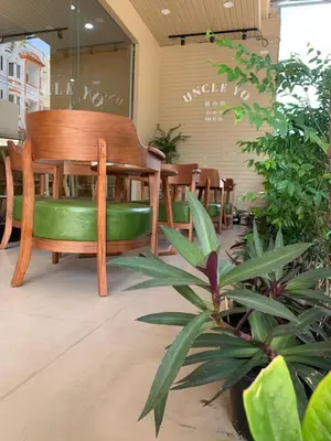 a wooden bench sitting in a room with plants at Uncle Yo House in Ban Tha Khreng
