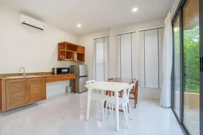 a kitchen with a table and chairs and a kitchen with a sink at A101 Banjong 1 Bed apart Near Nai Harn Beach in Rawai Beach