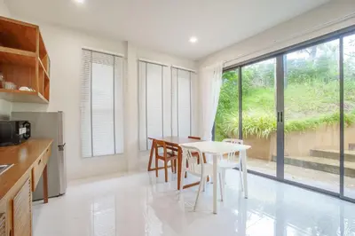 a kitchen with a white table and chairs and a window at A101 Banjong 1 Bed apart Near Nai Harn Beach in Rawai Beach