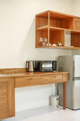 a kitchen with a wooden table with a microwave at A101 Banjong 1 Bed apart Near Nai Harn Beach in Rawai Beach
