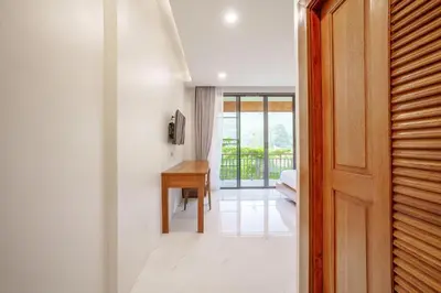a hallway with a door leading to a room with a desk at A101 Banjong 1 Bed apart Near Nai Harn Beach in Rawai Beach