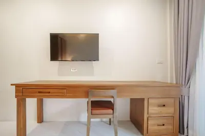 a wooden desk with a television on top of it at A101 Banjong 1 Bed apart Near Nai Harn Beach in Rawai Beach
