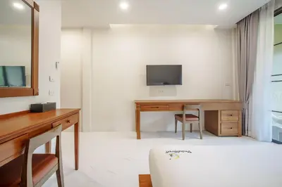 a room with a desk and a tv on a wall at A101 Banjong 1 Bed apart Near Nai Harn Beach in Rawai Beach