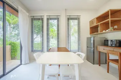 a kitchen with a white table and white chairs at A102 Banjong 1 Bed apart Near Nai Harn Beach in Rawai Beach