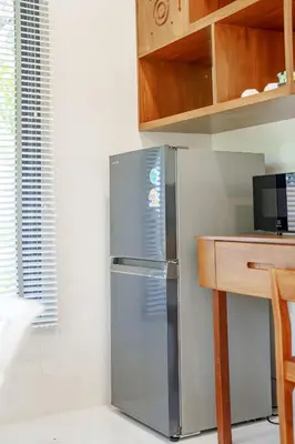a stainless steel refrigerator in a kitchen with a desk at A102 Banjong 1 Bed apart Near Nai Harn Beach in Rawai Beach