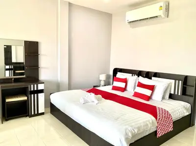 a bedroom with a large bed with red and white pillows at Chernin Apartment Suites in Ban Saiyuan (1)
