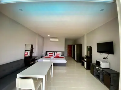 a large room with a bed and a television at Chernin Apartment Suites in Ban Saiyuan (1)