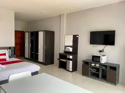 a bedroom with a bed and a flat screen tv at Chernin Apartment Suites in Ban Saiyuan (1)