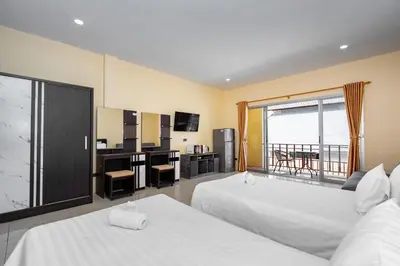 a hotel room with two beds and a balcony at Chernin Apartment Suites in Ban Saiyuan (1)